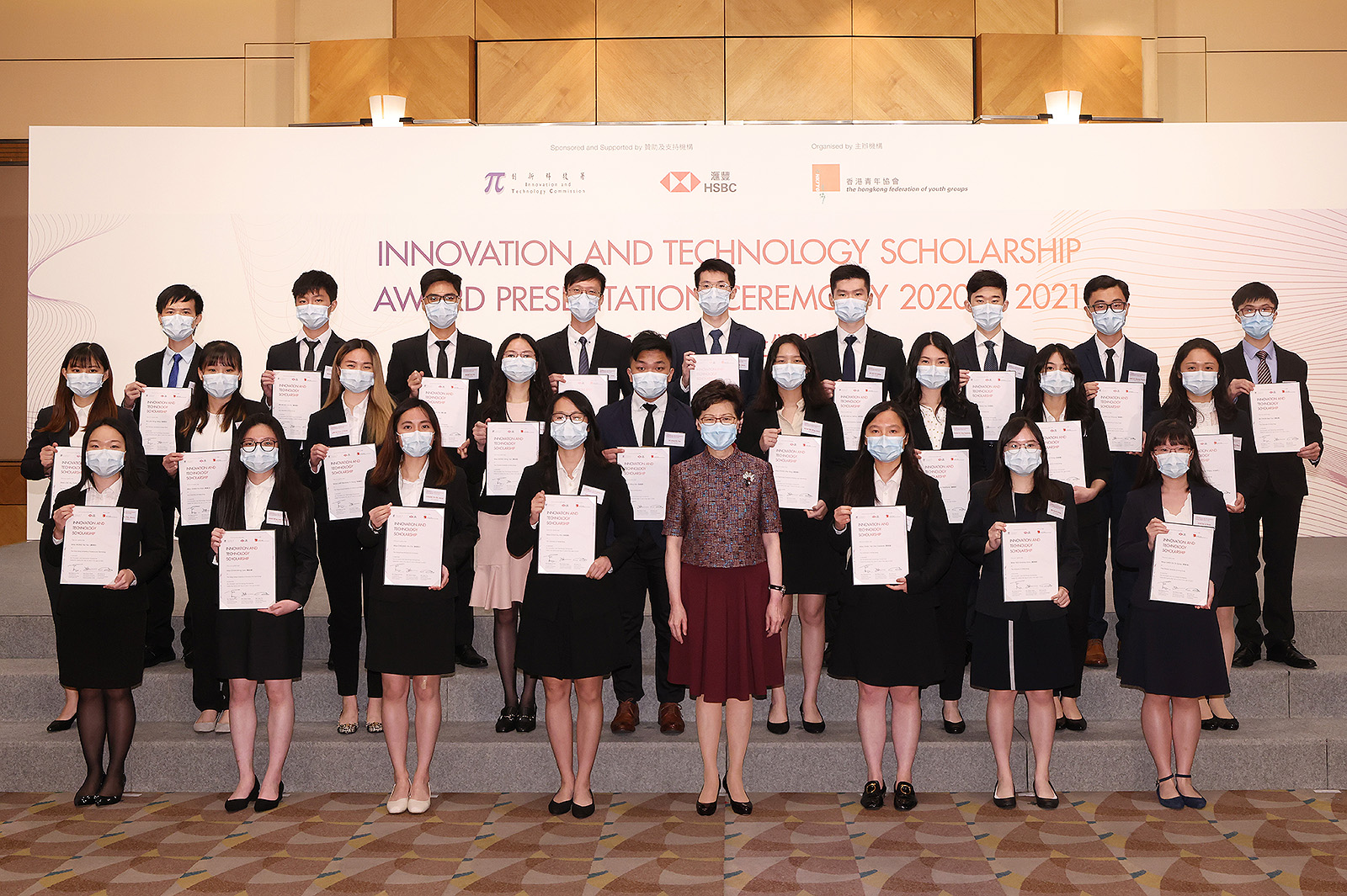The four CityU awardees, Monica Chan and Harvey Ng (2nd and 5th from left in 2nd row); and Andy Wong and Xavier Yeung (2nd and 3rd from left in 3rd row) received their certificates from the Chief Executive of the HKSAR, Mrs Carrie Lam Cheng Yuet-ngor, at the Innovation and Technology Scholarship Award Presentation Ceremony on 21 June. 